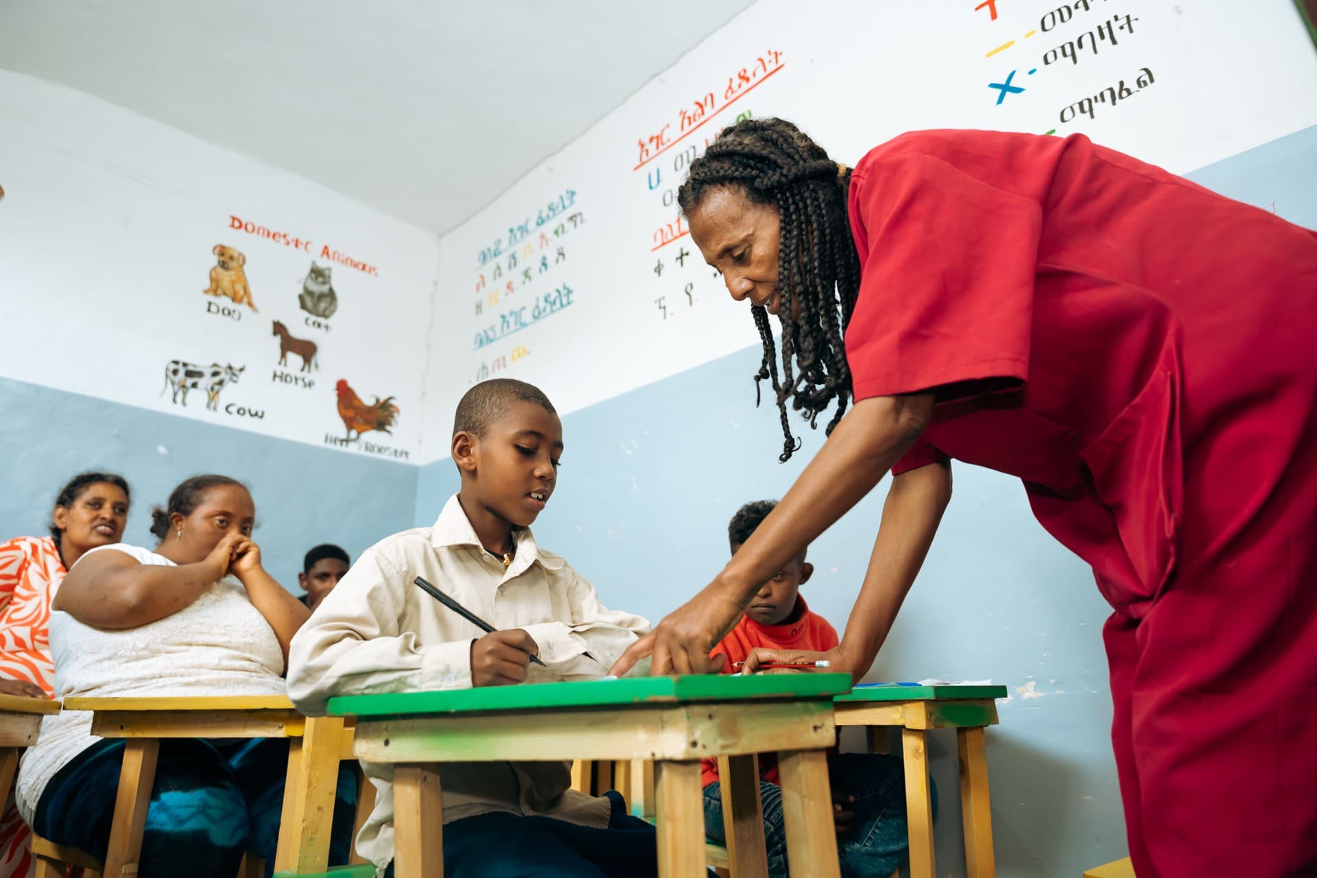 Teacher guiding children during classroom learning